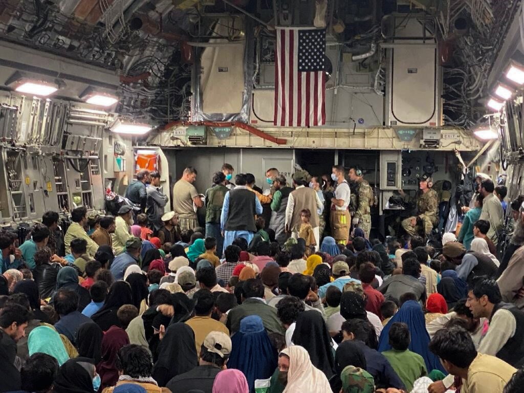 A newborn baby is being looked after prior to being taken off a C-17 Globemaster III, August 23, 2021 at a Middle East staging area. (U.S. Air Force courtesy photo)
