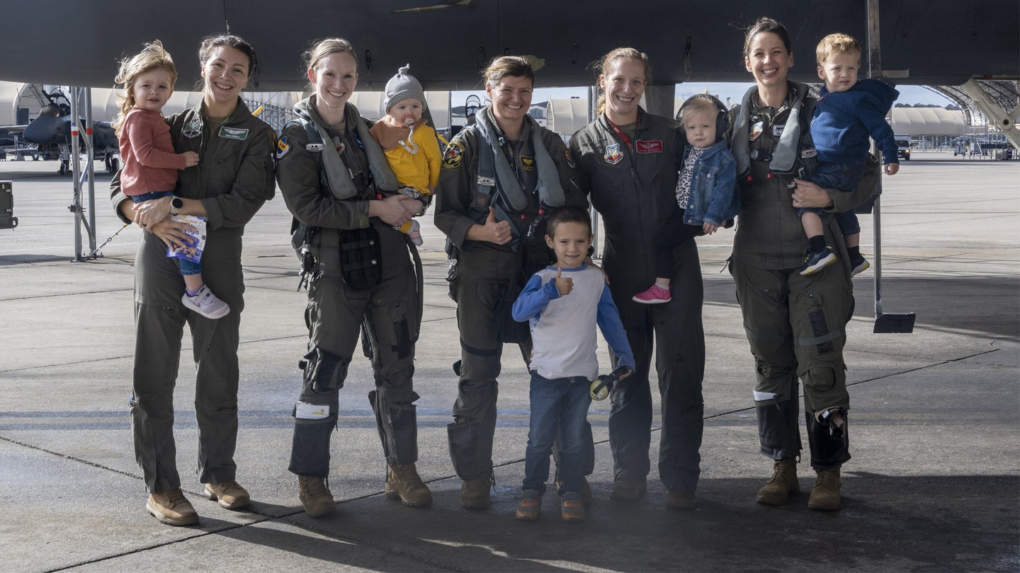 F-15E Strike Eagle fighter pilots assigned to the 4th Fighter Wing pose with their children at Seymour Johnson Air Force Base, North Carolina, Nov. 9, 2022. McElroy chose fellow 4th FW fighter pilot moms to accompany her on her final flight with the 333rd Fighter Squadron. (Senior Airman Kylie Barrow/U.S. Air Force)