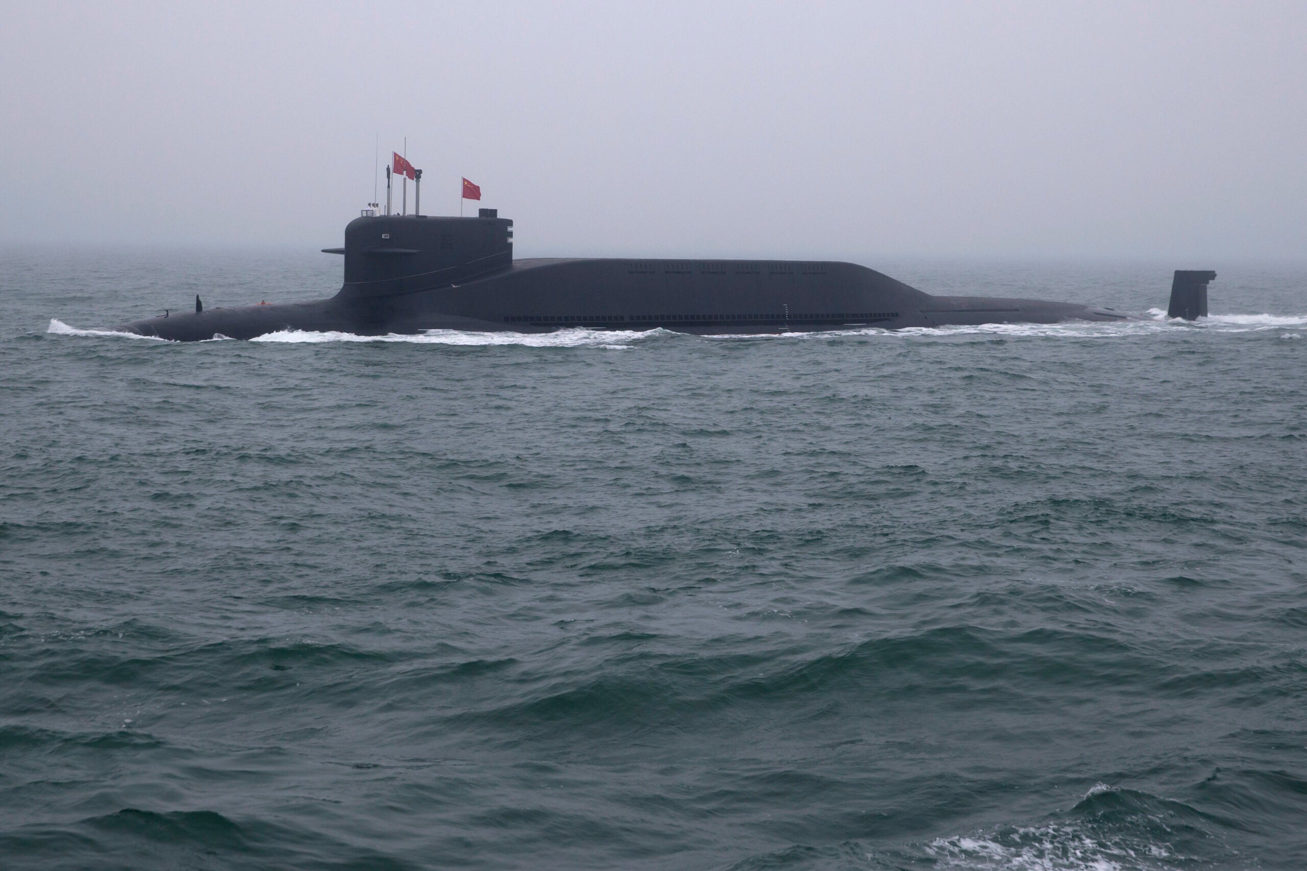 A type 094 Jin-class nuclear submarine Long March 15 of the Chinese People's Liberation Army (PLA) Navy participates in a naval parade to commemorate the 70th anniversary of the founding of China's PLA Navy in the sea near Qingdao, in eastern China's Shandong province on April 23, 2019. - China celebrated the 70th anniversary of its navy by showing off its growing fleet in a sea parade featuring a brand new guided-missile destroyer. (Photo by Mark Schiefelbein / POOL / AFP)        (Photo credit should read MARK SCHIEFELBEIN/AFP via Getty Images)