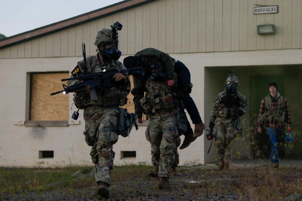 U.S. Army Spc. Conner Crisafi (left), Sgt. Garret Paulson, (center), Spc. Paulo Dasilva (right), of Squad 9, representing the U.S. Army Medical Command, transport a casualty during the Army’s first-ever Best Squad Competition on Fort Bragg, North Carolina, Oct 4, 2022. (Spc. James B. Paxson/U.S. Army)