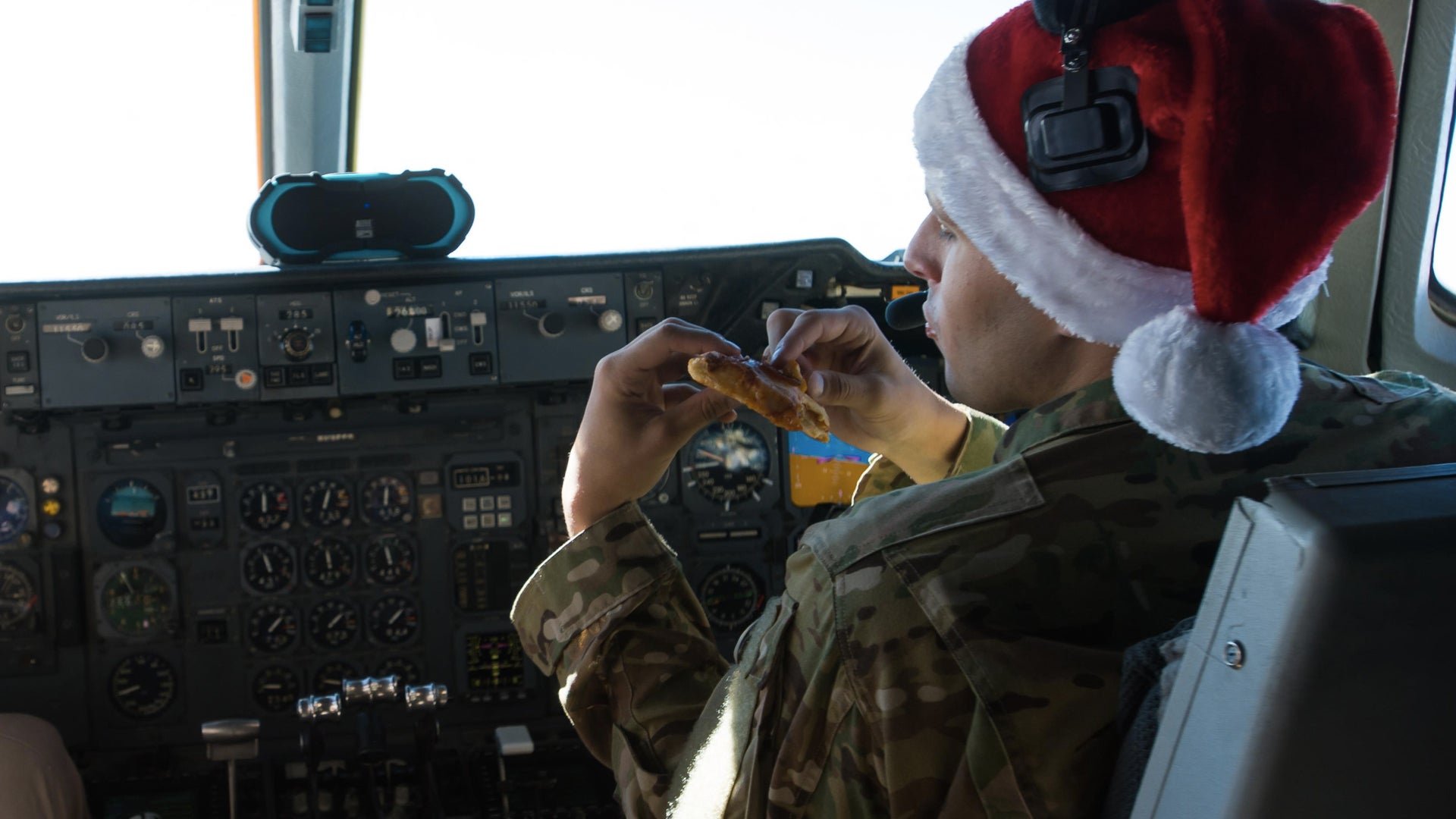 First Lt. Andrew, a 380th Air Expeditionary Wing KC-10 Extender pilot, eats reheated pizza during a sortie in support of Combined Joint Task Force-Operation Inherent Resolve over Iraq, Dec. 25, 2016. Crew members used two small ovens to prepare their holiday meal. (Senior Airman Tyler Woodward/U.S. Air Force)
