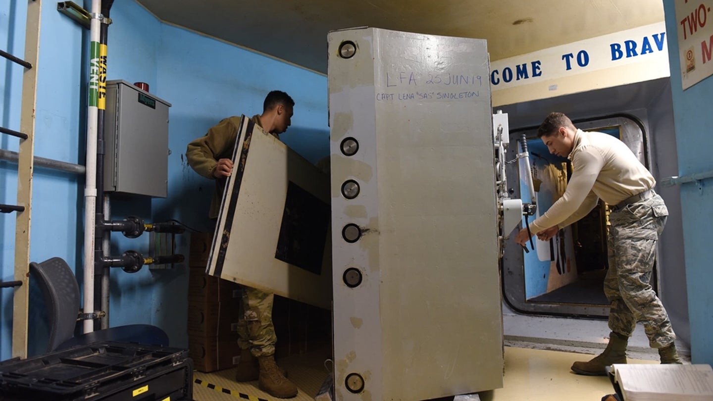 Airman 1st Class Anthony White, left, and Senior Airman Mark McCormick, 341st Missile Maintenance Squadron survivable systems team members, perform maintenance on a launch control center blast door Oct. 29, 2019, at a Missile Alert Facility near Malmstrom Air Force Base, Mont. The SST’s primary task is to perform LCC maintenance, including the blast door. (Airman 1st Class Jacob M. Thompson/U.S. Air Force)