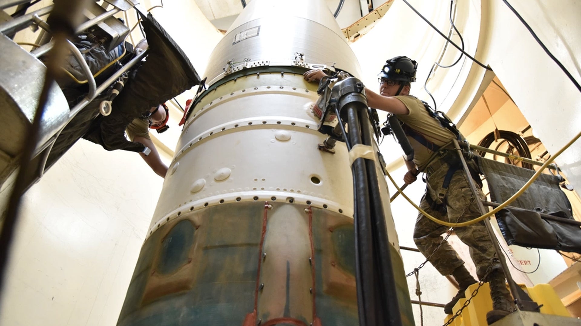 Airman 1st Class Jackson Ligon, left, and Senior Airman Jonathan Marinaccio, 341st Missile Maintenance Squadron technicians, connect a re-entry system to a spacer on an intercontinental ballistic missile during a Simulated Electronic Launch-Minuteman test Sept. 22, 2020, at a launch facility near Great Falls, Mont. (Senior Airman Daniel Brosam/U.S. Air Force))