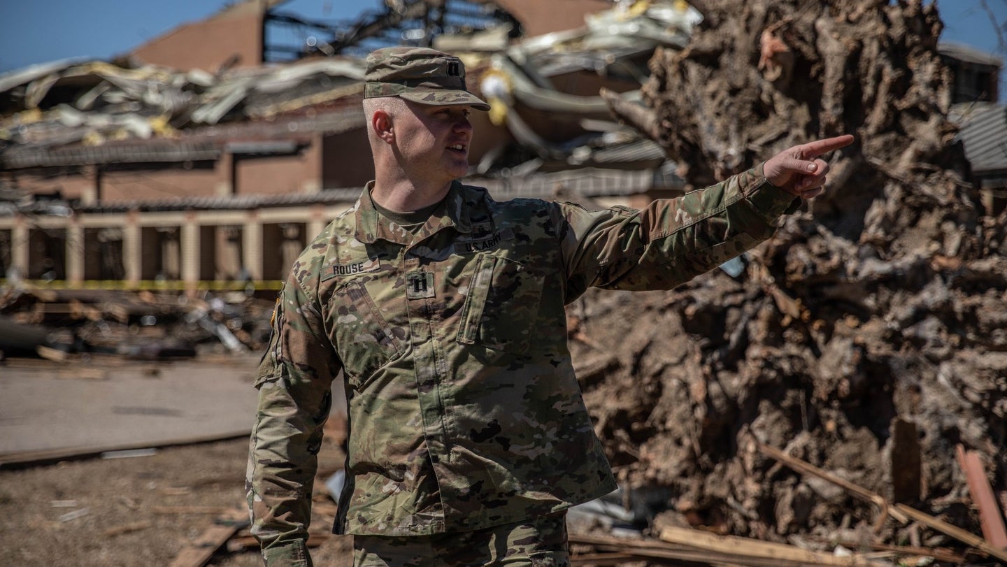 A member of the Arkansas National Guard stands in front of damaged areas following a series of tornadoes. (photo courtesy Arkansas National Guard)