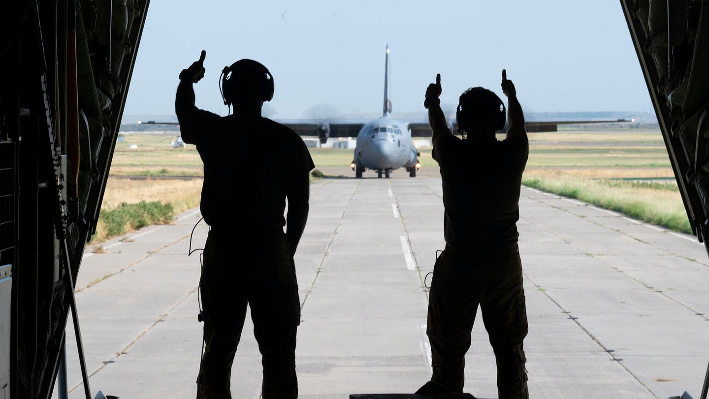 U.S. Air Force Tech. Sgt. Mario Linton, 37th Airlift Squadron loadmaster, left, and Senior Airman Robert Kucholtz, 37th AS loadmaster, give a thumbs up to the 37th AS pilots of a U.S. Air Force C-130J Super Hercules aircraft during exercise Agile Spirit 21 at Tbilisi, Georgia, July 27, 2021. Linton and Kucholtz showed their enthusiasm after successful navigation of Georgian airspace. Agile Spirit 2021 is a joint, multinational exercise co-led by the Georgian Defense Forces and U.S. Army Europe and Africa. Agile Spirit enhances U.S., Georgian, allied and partner forces' lethality, interoperability and readiness in a realistic training environment. (U.S. Air Force photo by Senior Airman Milton Hamilton)