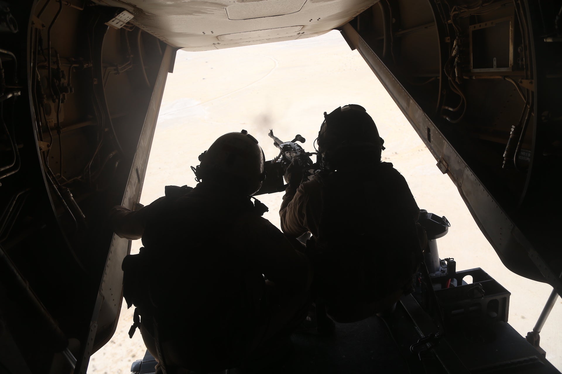 U.S. Marine Corps Sgt. Daniel Pacheco, left, and Cpl. Jared Arnold, right, crew chiefs with Marine Medium Tiltrotor Squadron 265, Marine Aircraft Group 36, 1st Marine Aircraft Wing, fire an M240D machine gun from the back of an MV-22B Osprey aircraft, during a tail gunnery certification in support of Weapons and Tactics Instructor (WTI) course 1-21 in Yuma, Arizona, Oct. 6, 2020. The WTI course is a seven-week training event hosted by Marine Aviation Weapons and Tactics Squadron One, providing standardized advanced tactical training and certification of unit instructor qualifications to support Marine aviation training and readiness, and assists in developing and employing aviation weapons and tactics. (U.S. Marine Corps photo by Cpl. KarlHendrix Aliten)