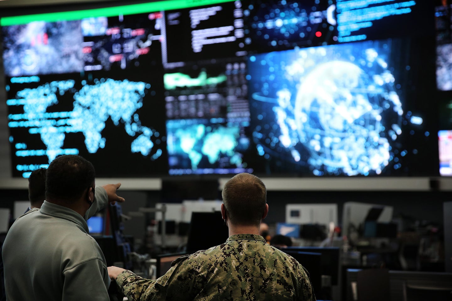 Military personnel look at digital, cyber information.