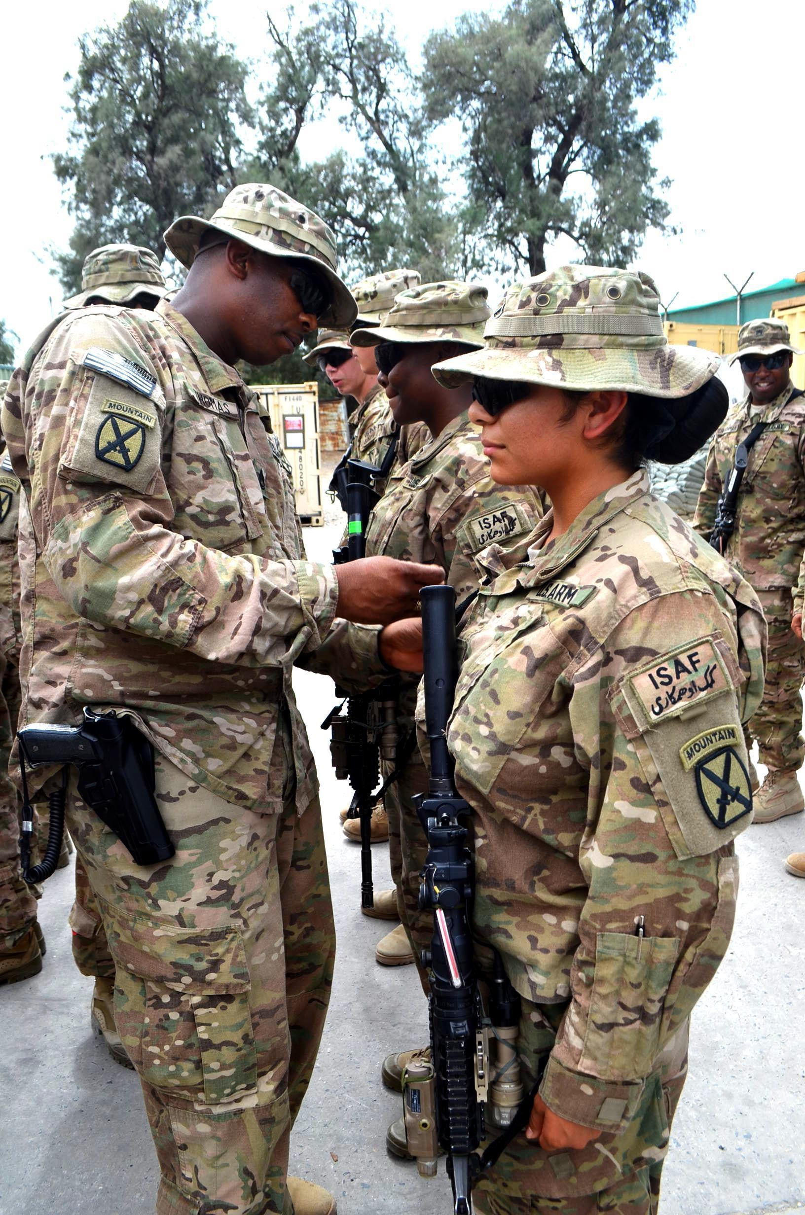 U.S. Army Sgt. 1st Class Ricky Thomas, operations noncommisioned officer in charge, 4th Brigade Special Troops Battalion, Task Force Dagger, from Ville Platte, La., places a 10th Mountain Division Patch on the right shoulder of Pfc. Michelle Garcia, a human resources specialist with 4th BSTB from Belton, Texas, during the battalion's deployment patch ceremony at Forward Operating Base Fenty Aug. 17, 2013. Soldiers earn the right to wear an organization's patch on their right shoulder when they serve with that unit in combat. TF Dagger is part of 4th Brigade, 10th Mountain Division, based out of Fort Polk, La. (U.S. Army Photo by Sgt. Anna Simms, Task Force Patriot)