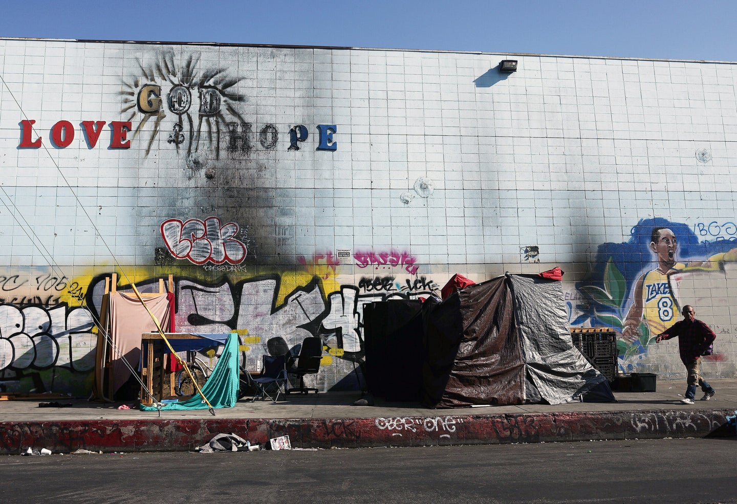 LOS ANGELES, CALIFORNIA - SEPTEMBER 28: A person walks past a homeless encampment in the Skid Row community on September 28, 2023 in Los Angeles, California. State and local lawmakers, both Republicans and Democrats, are seeking to overturn lower court decisions which currently block their power to clear encampments with unhoused people. Dozens of leaders, many from Western states including California, have turned to the Supreme Court to overturn the rulings. Skid Row is home to thousands of people who either live on the streets or in shelters. (Photo by Mario Tama/Getty Images)