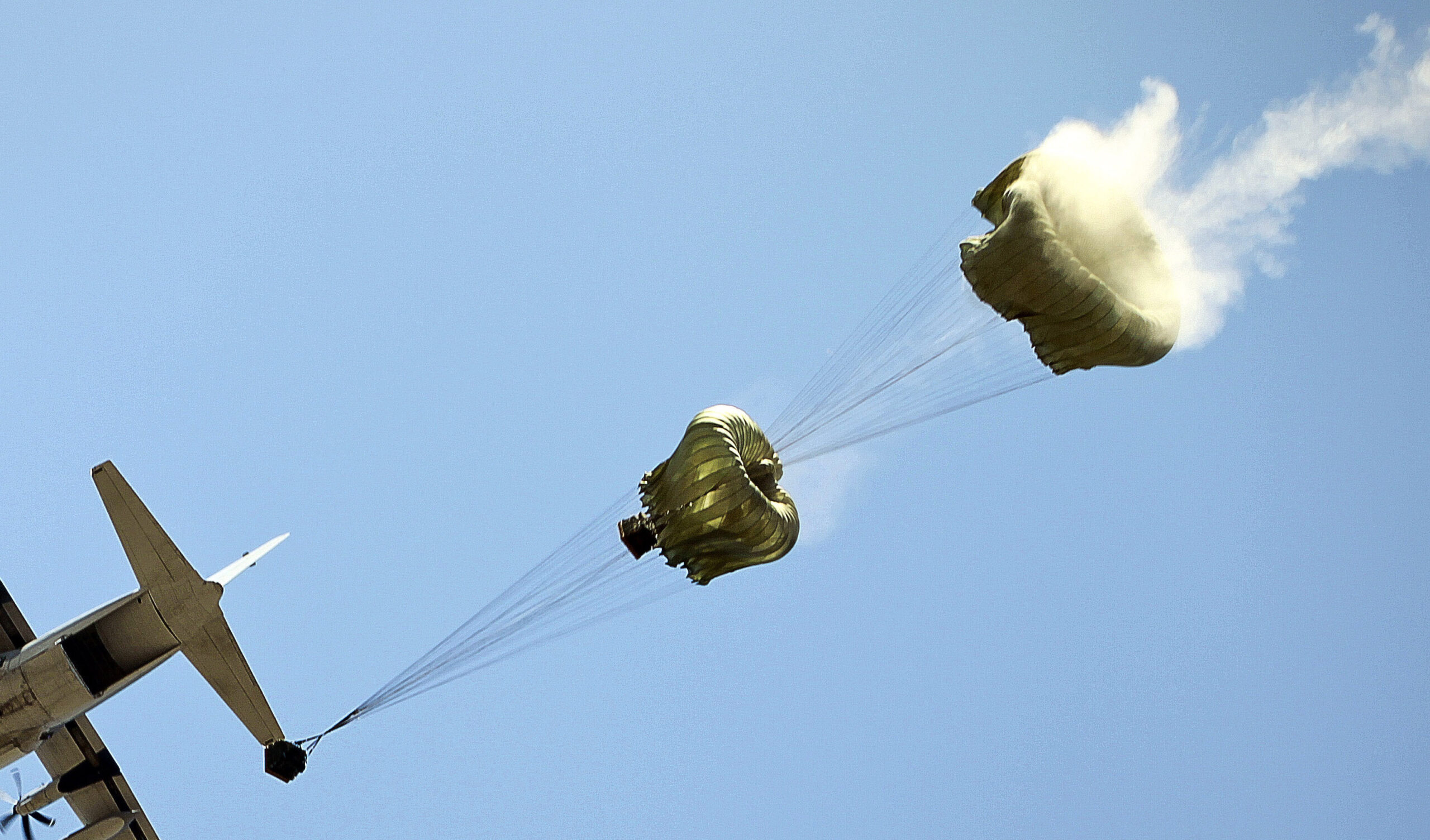 A U.S. Marine Corps C-130 drops container delivery systems with water cargo. Marine Corps photo.