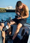A Navy combat cameraman filming diving preparation. 