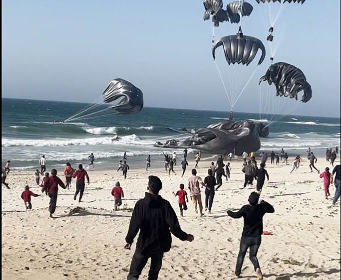 Parachutes carrying aid bundles dropped from a U.S. plane land in the water and on a beach in Gaza on March 2. The parachutes used in that drop were large "low velocity" designed to fall at less than 20 miles per hour. The parachutes used in the March 8 drop appear to have been high velocity parachutes, designed to fall at up to 60 mph.  Screengrab from AFPTV via Getty Images.