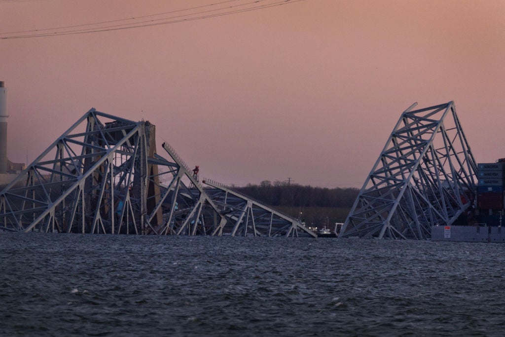 BALTIMORE, MARYLAND - MARCH 29: The sun sets on the collapsed Francis Scott Key Bridge on March 29, 2024 in Baltimore, Maryland. The bridge, which was used by roughly 30,000 vehicles each day, fell into the Patapsco River after being struck by the Dali, a cargo ship leaving the Port of Baltimore at around 1:30am on Tuesday morning on March 26th. The bodies of two men who were on the bridge at the time of the accident have been recovered from the water, four other are still missing and presumed dead, two others were rescued and treated for injuries shortly after the accident. The Port of Baltimore, one of the largest and busiest on the East Coast of the U.S., remains temporarily closed due to the incident. (Photo by Scott Olson/Getty Images)
