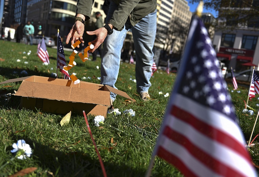 volunteer collects symbolic pill bottles