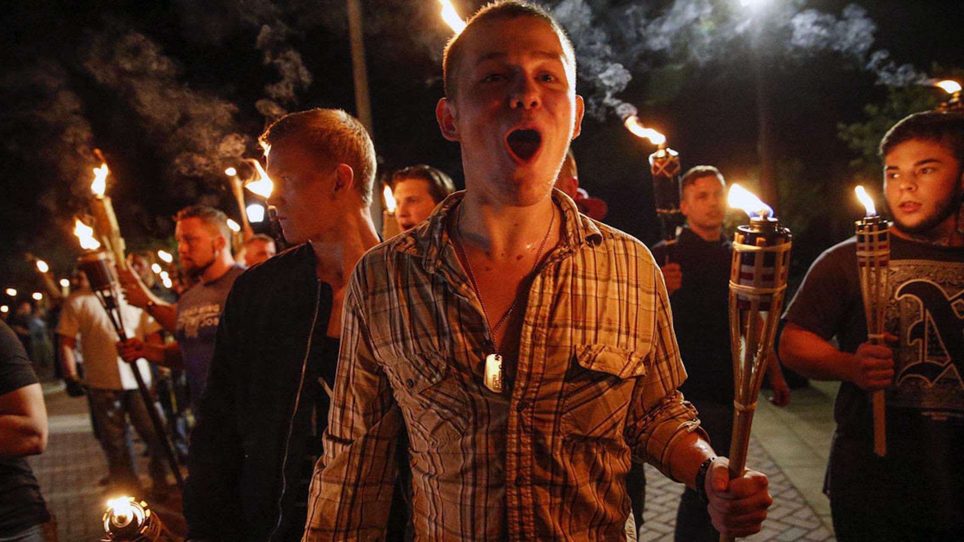 In this photo taken Friday, Aug. 11, 2017, multiple white nationalist groups march with torches through the UVA campus in Charlottesville, Va. Hundreds of people chanted, threw punches, hurled water bottles and unleashed chemical sprays on each other Saturday after violence erupted at a white nationalist rally in Virginia. (Mykal McEldowney/The Indianapolis Star via AP)