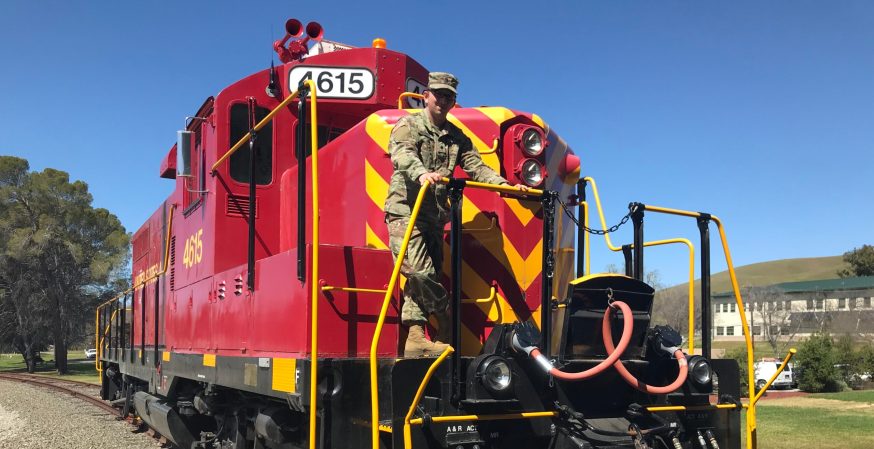 Josh Biggers stands in front of a train.