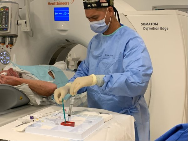 A doctor preparing to perform a medical procedure on a veteran.