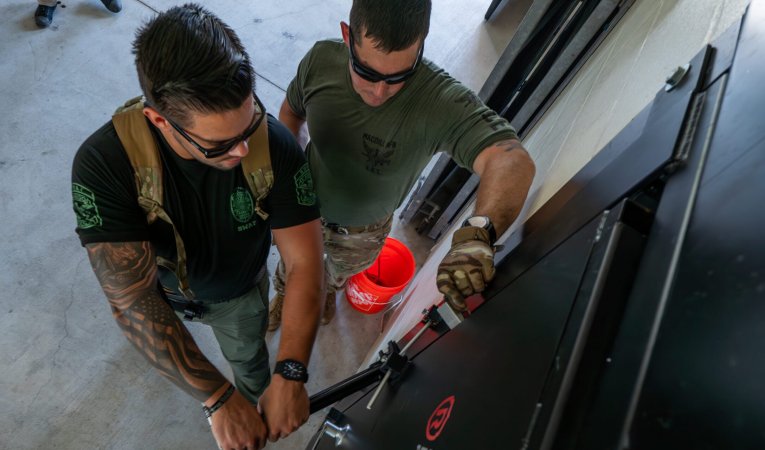 U.S. Airmen use a new tool to breach a SCIF door.