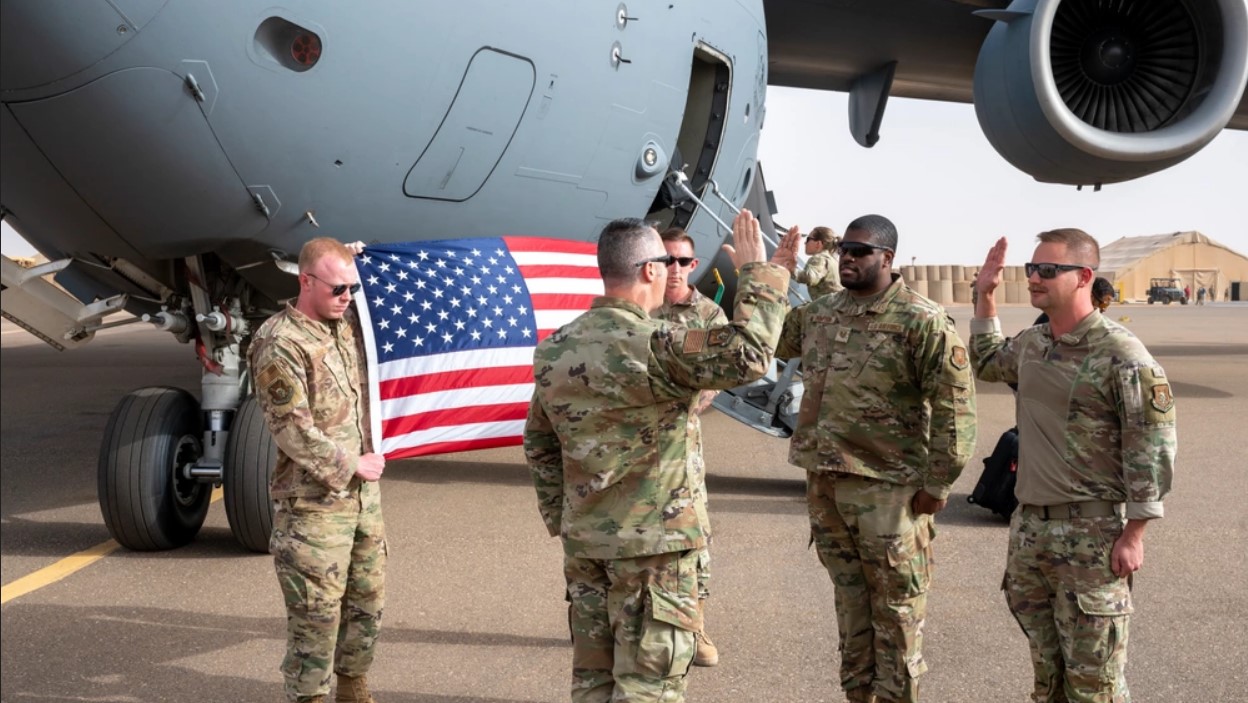 Air Force members Tech. Sgt. Tyrese Thompson and Tech. Sgt. Chase Blumberg reenlist at Air Base 201 in Niger in 2023.
