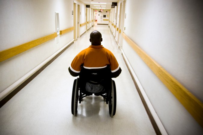 WASHINGTON, D.C. - MARCH 17: Eugene Simpson, 29, from Dale City, Virginia goes through physical therapy at the Veterans Affairs Medical Center in Washington, D.C. with Michael Minor, a kinesiotherapist with the United States Department of Veterans Affairs on March 17, 2006 in Washington, D.C., USA. Simpson, was left paralyzed after an Improvised Explosive Device (I.E.D.) wounded him while on patrol outside of Tikrit, Iraq on while serving as a United States soldier on April 7, 2004. Prior to his injury, Simpson had been a standout athlete, playing both football and basketball in college. (Photo by Jeff Hutchens/Getty Images)