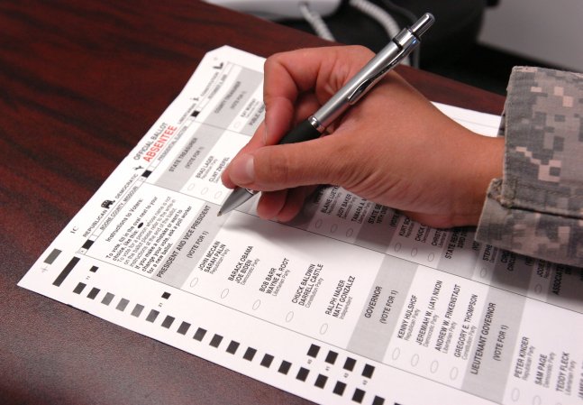 A Joint Task Force Guantanamo Trooper fills out an absentee ballot for the upcoming presidential election, Oct. 8, 2008. Every JTF Trooper has the opportunity to register and vote while serving on U.S. Naval Station Guantanamo Bay via absentee ballot. JTF Guantanamo conducts safe, humane, legal and transparent care and custody of detained enemy combatants, including those convicted by military commission and those ordered released. The JTF conducts intelligence collection, analysis and dissemination for the protection of detainees and personnel working in JTF Guantanamo facilities and in support of the Global War on Terror. JTF Guantanamo provides support to the Office of Military Commissions, to law enforcement and to war crimes investigations. The JTF conducts planning for and, on order, responds to Caribbean mass migration operations.