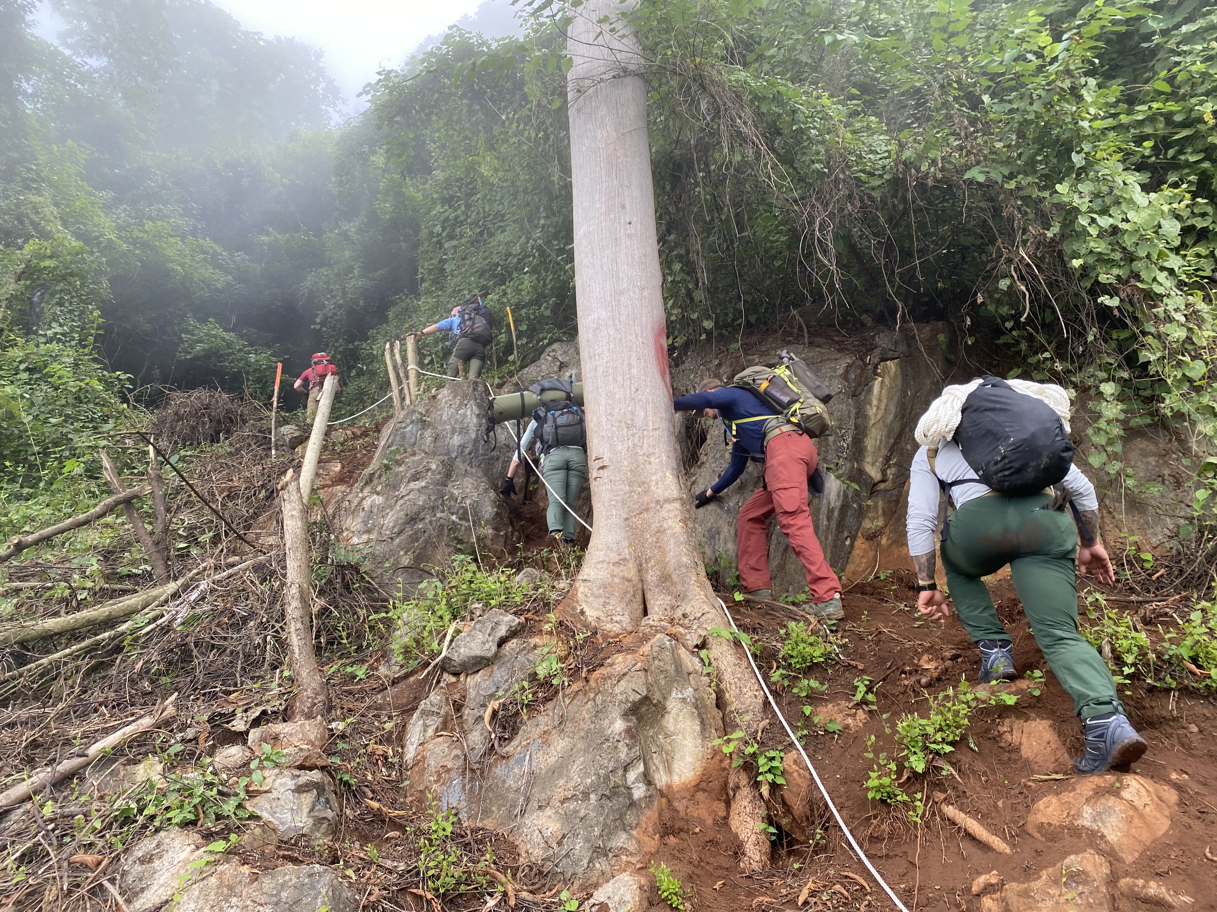 DPAA investigation team traversing the mountain side of the former Lima Site 85.