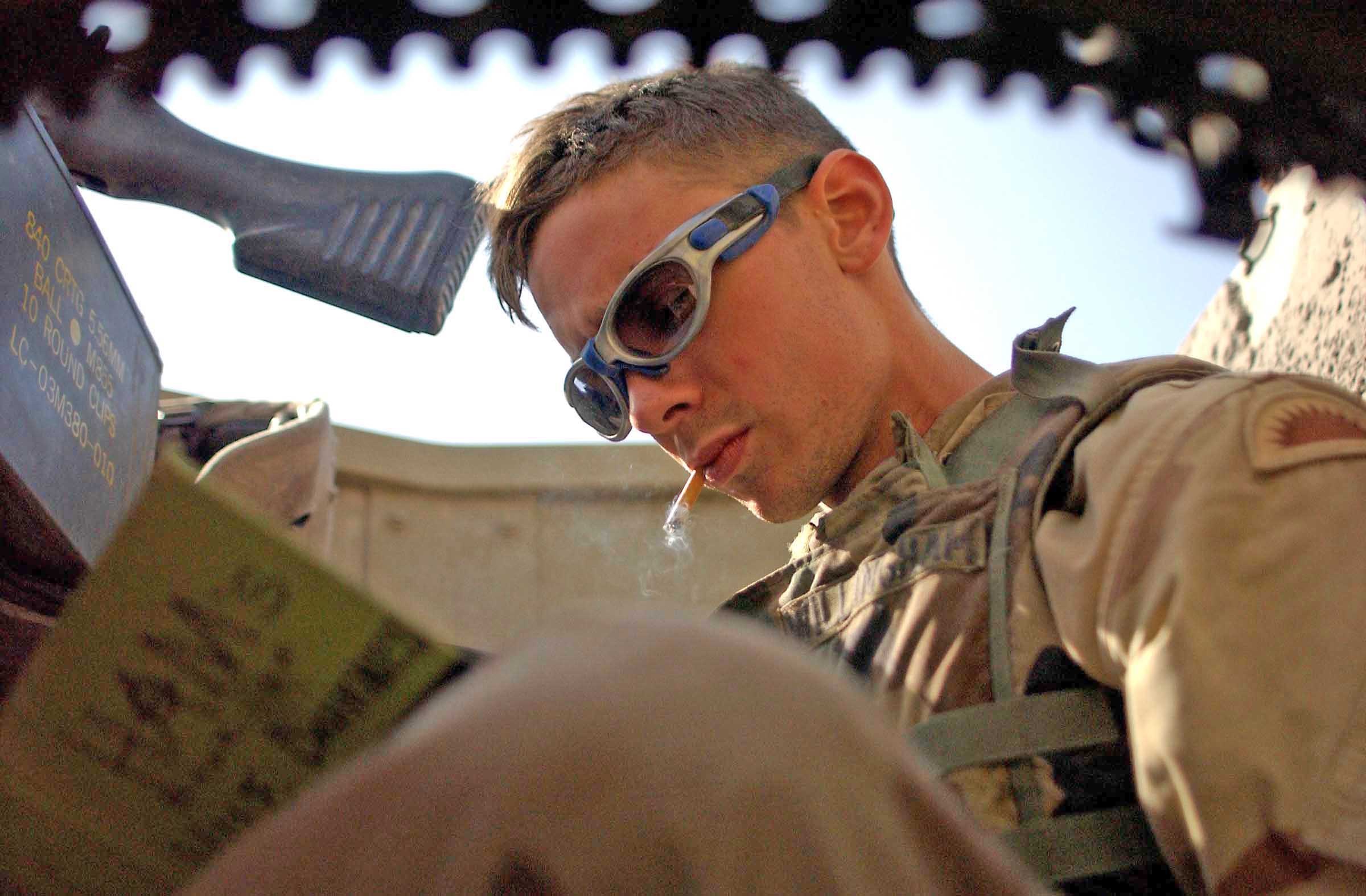 Soldier smoking from the turret position while writing a letter to his girlfriend.