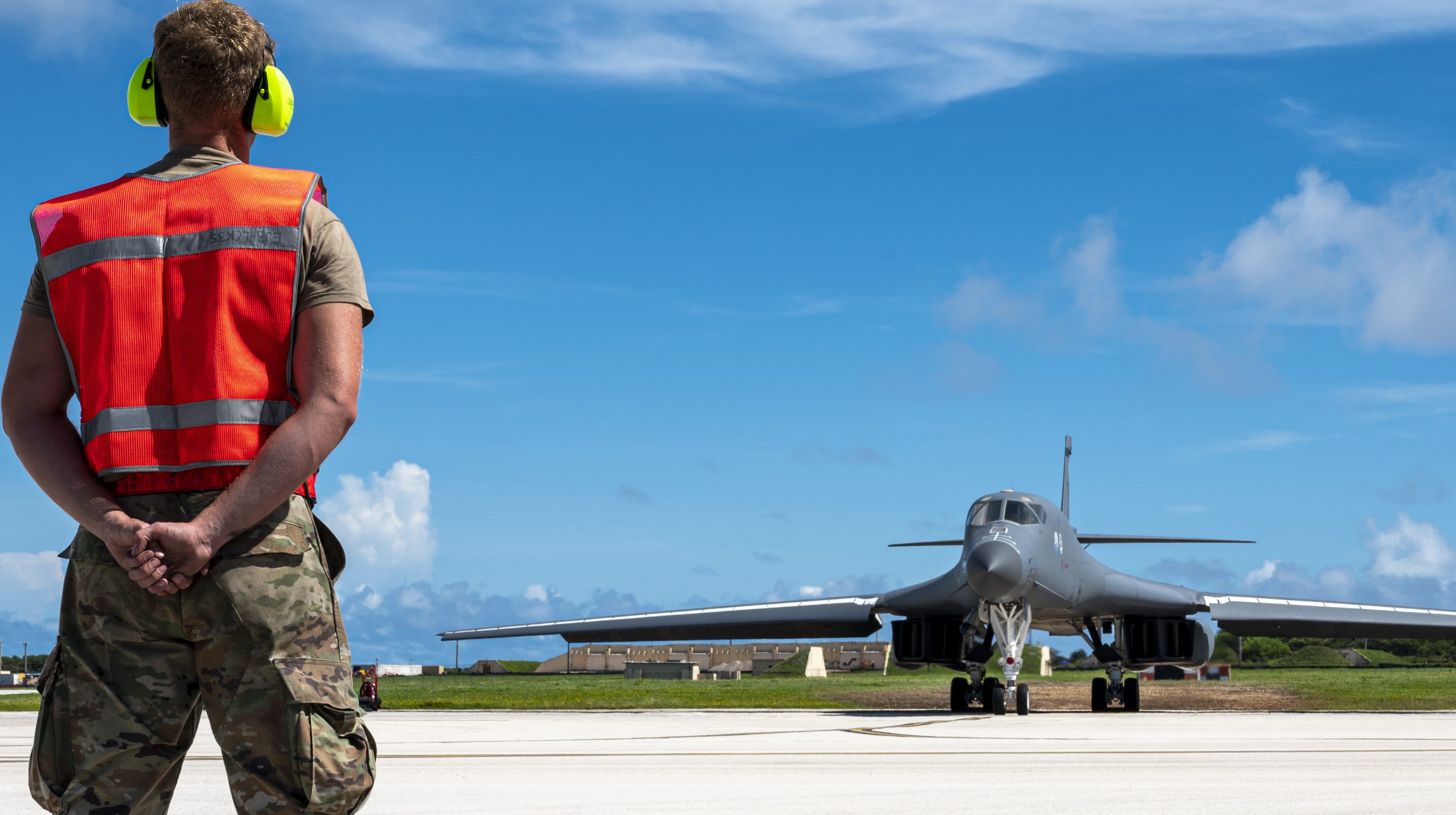 An aircraft maintainer, assigned to 34th Aircraft Maintenance Unit, prepares to marshal a U.S. Air Force B-1B Lancer, assigned to 34th Expeditionary Bomb Squadron, to takeoff from Andersen Air Force Base, Guam, to support a Bomber Task Force mission, June 29. Bomber Task Force missions provide opportunities to train alongside our allies and partners to build interoperability and bolster our collective ability to support a free and open Indo-Pacific. (U.S. Air Force photo by Master Sgt. Nicholas Priest)