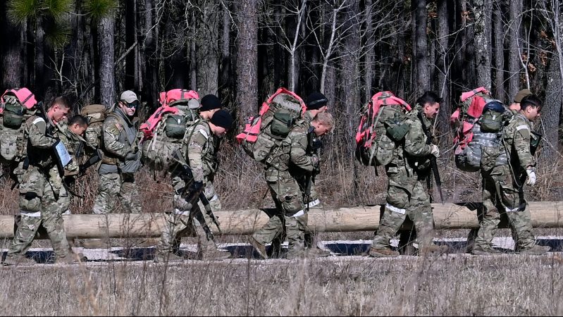 Special Forces Assessment and Selection candidates carrying a log during a team building exercise.