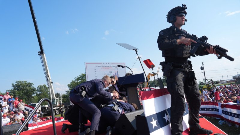 Secret service agents cover former president Donald Trump during a campaign rally for former President Donald Trump at Butler Farm Show Inc. on Saturday, July 13, 2024 in Butler, Pa. Trump ducked and was taken offstage after loud noises were heard after he began speaking. (Photo by Jabin Botsford/The Washington Post via Getty Images)