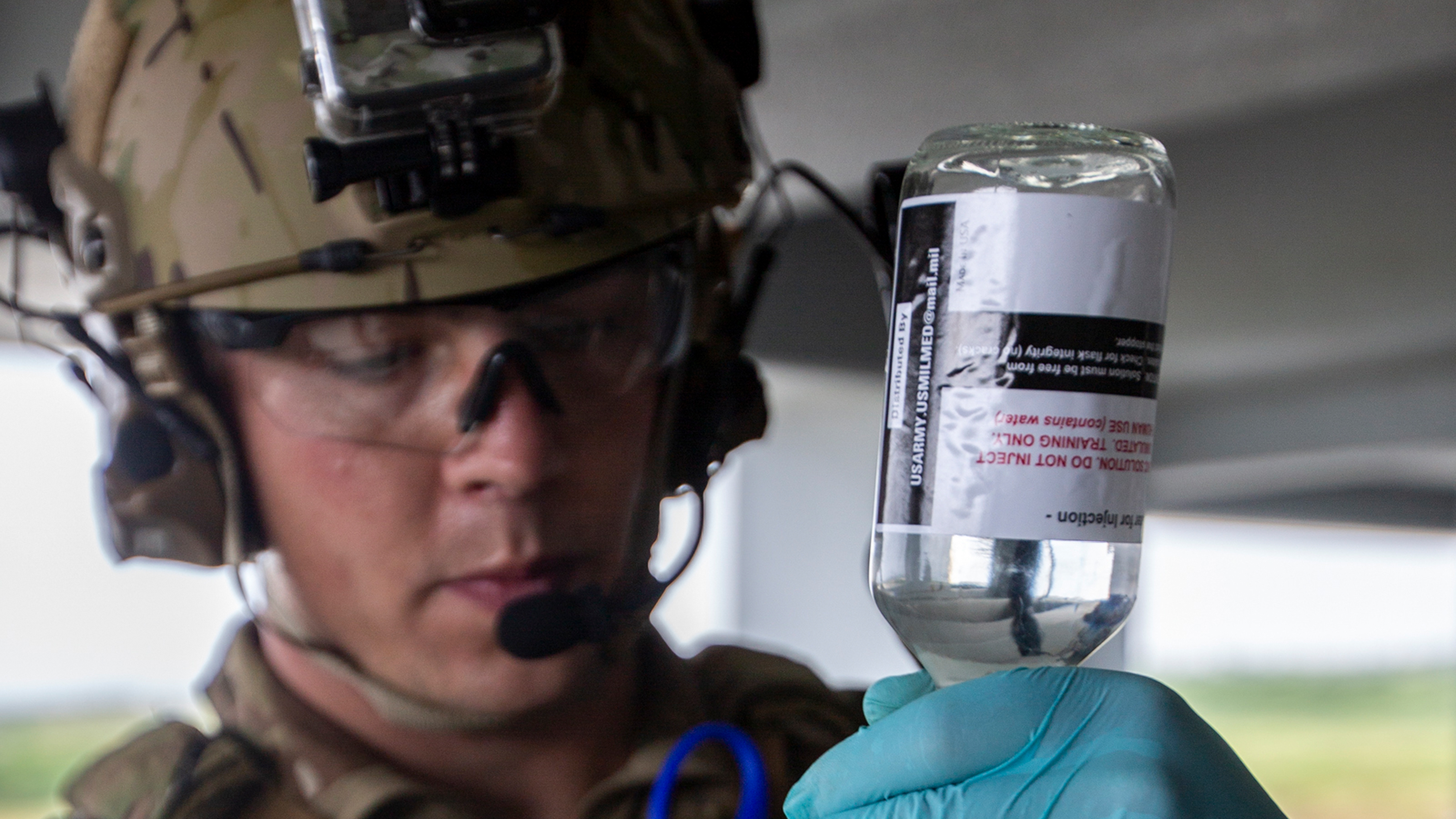 A soldier prepares freeze dried plasma during a military training exercise.