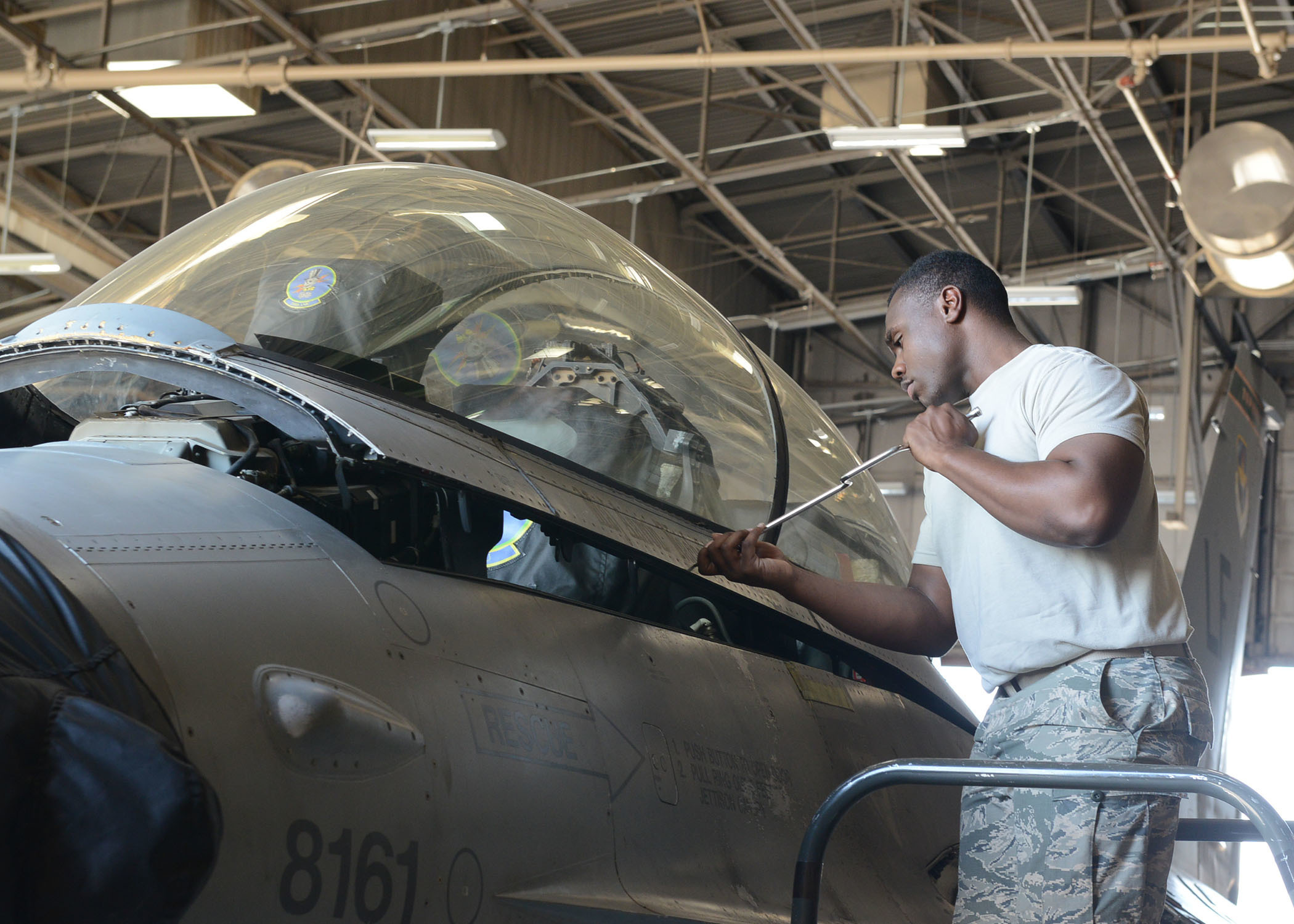 Airman 1st Class Diamond Balock White, 56th Component Maintenance Squadron aircrew egress technician, removes bolts from an F-16 Fighting Falcon canopy June 26, 2017, at Luke Air Force Base, Ariz. Balock White is preparing the canopy for removal to take out the ejection seat and perform routine maintenance. (U.S. Air Force photo by Senior Airman James Hensley)