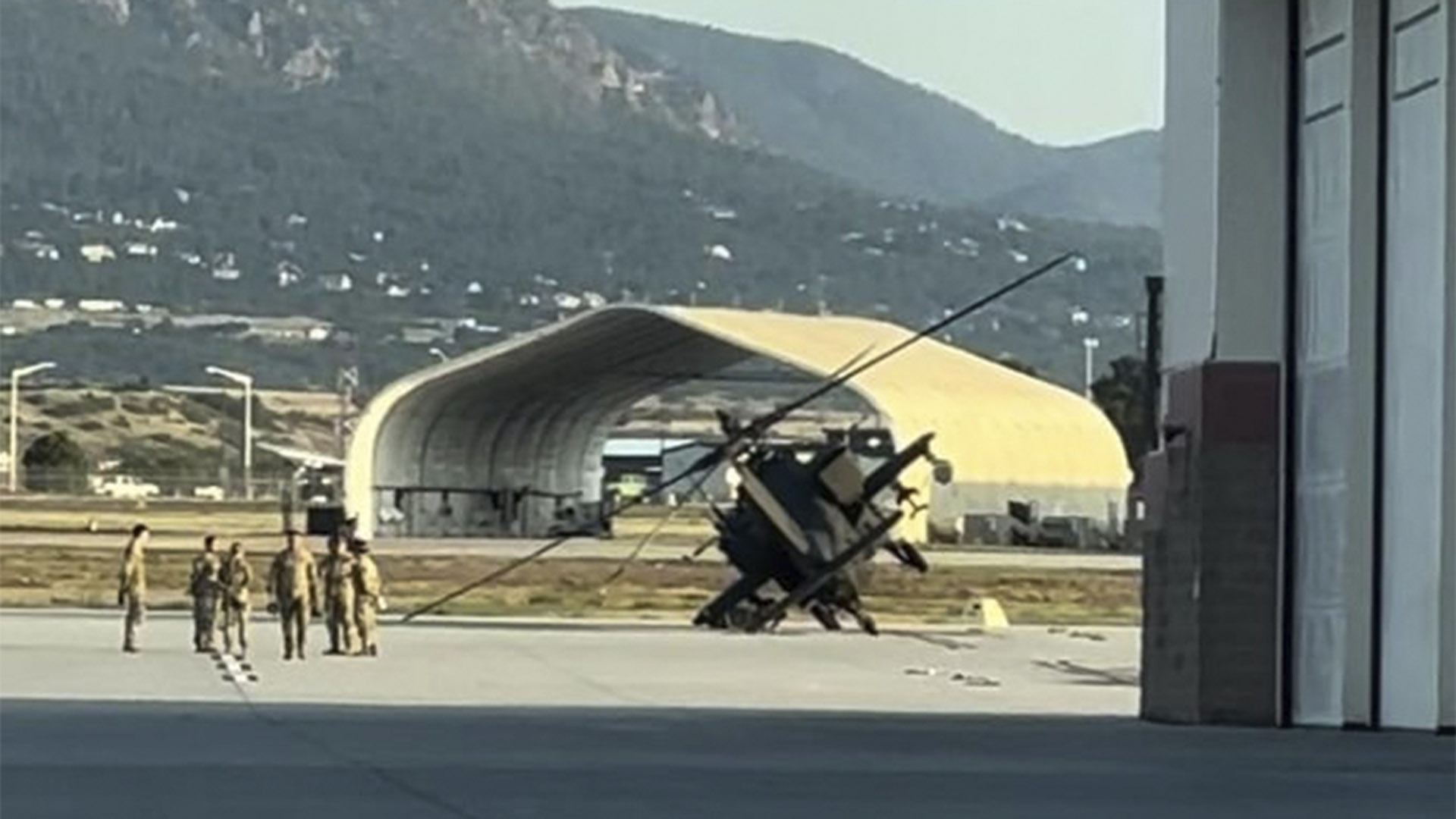 A helicopter knocked on its side after storms hit Fort Carson.