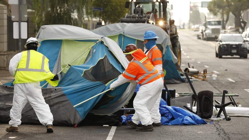 Crews dismantle a homeless veterans encampment on San Vincente Boulevard in Los Angeles on Nov. 1, 2021. The encampment was set up outside of the 388-acre West Los Angeles Veterans Affairs campus. (photo by Al Seib / Los Angeles Times via Getty Images).