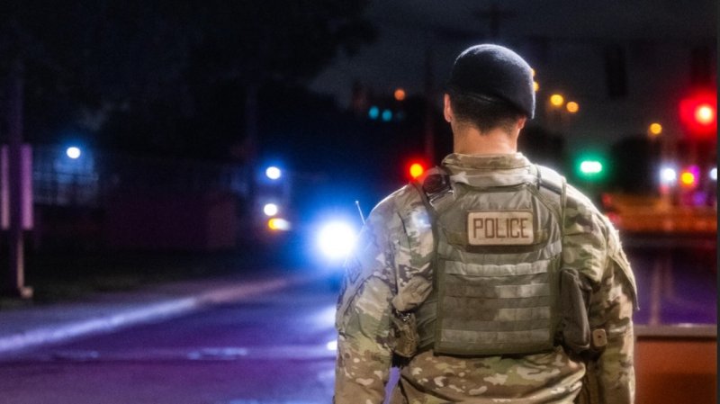 An airman with the 802nd Security Forces Squadron stands outside a gate to Joint Base San Antonio-Lackland, Texas in June, 2024. (photo by Brian Boisvert/U.S. Air Force)