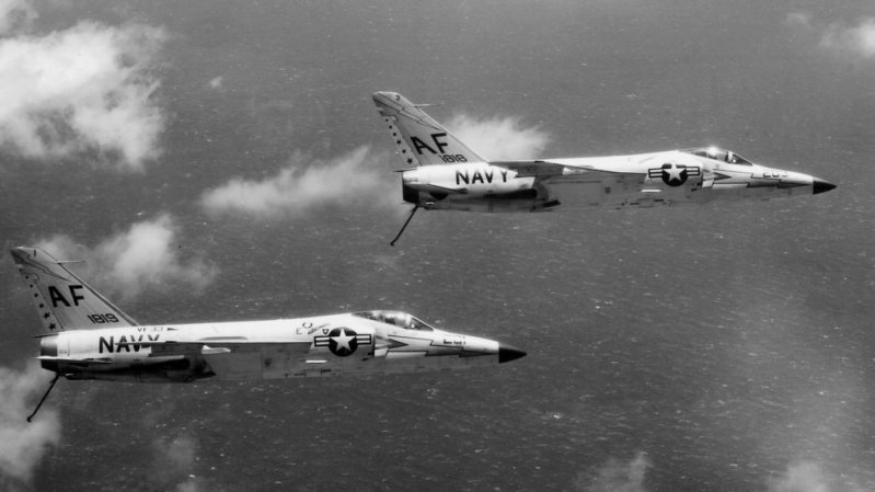 A black and white photo of two U.S. Navy F-11 Tigers flying together.