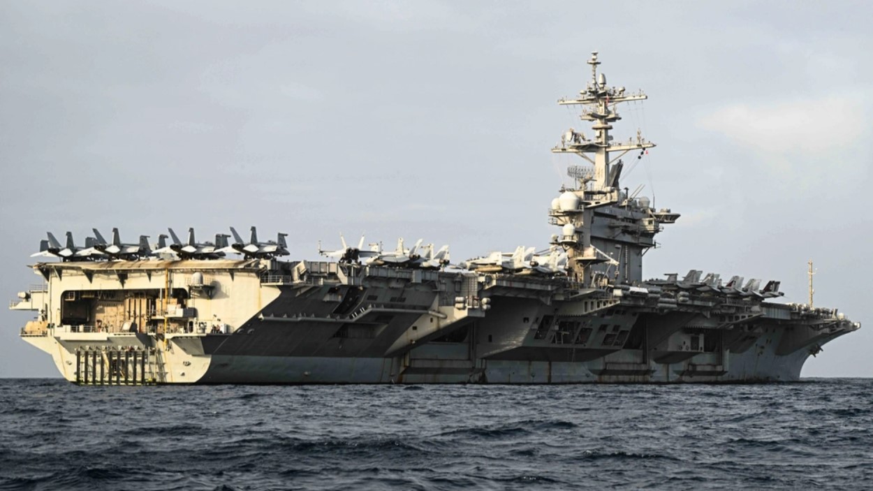 The aircraft carrier USS Theodore Roosevelt sails through the waters of the Middle East on Aug. 10, 2024. Fighter jets are visible on the deck of the ship. (U.S. Navy photo)