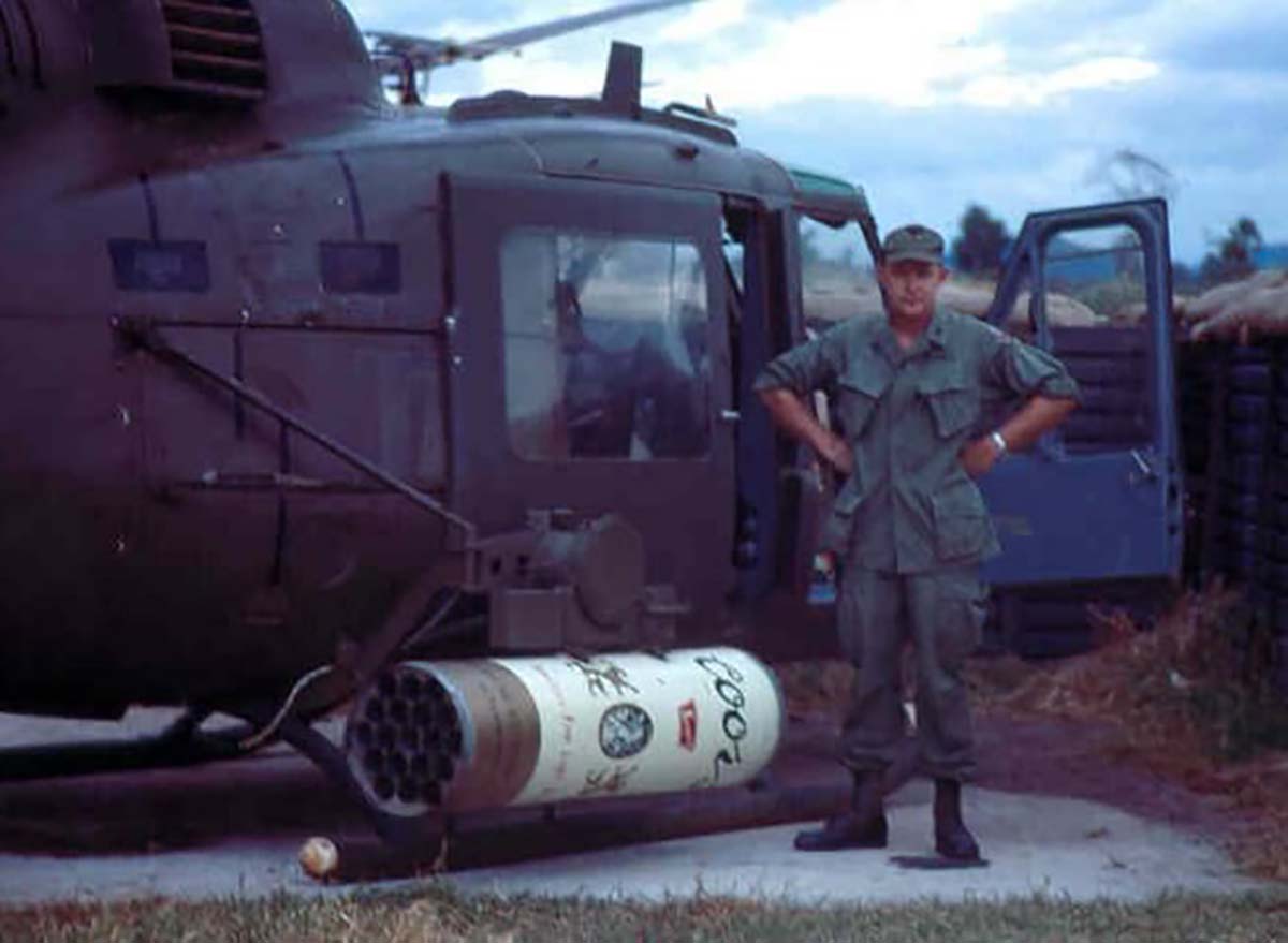 A soldier standing next to the Coors beer themed rocket pod. 