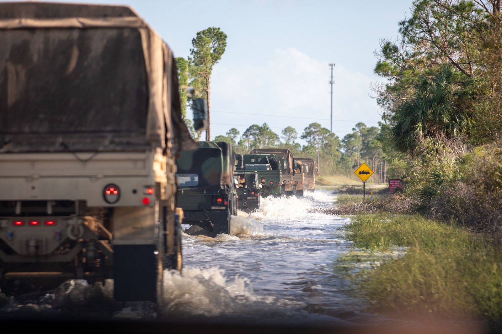 Soldiers from the 3-265th Air Defense Artillery clear road debris in Cedar Key while assisting law enforcement at a checkpoint as part of their route clearing patrol, Sept. 27, 2024. Response to Hurricane Helene is a massive team effort, and FLARNG fully mobilizes all available forces. (U.S. Army photo by 1st Lt. Brandon Miles, 107th MPAD, FLARNG)