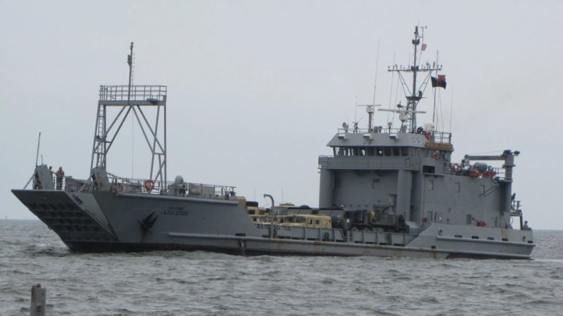 A US Army landing craft loaded with vehicles and artillery components floats in the waters off of Fort Story.