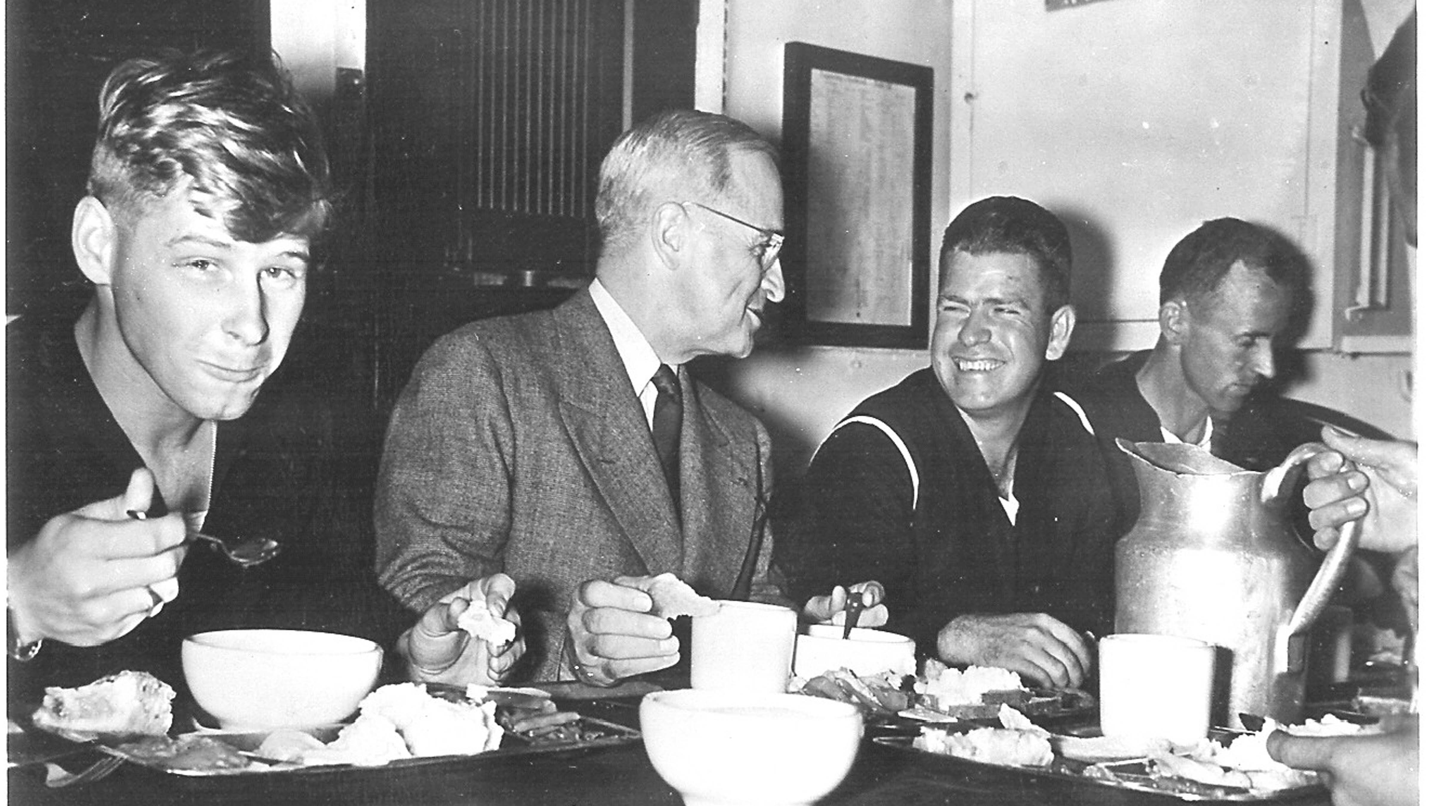 President Harry S. Truman eating a meal with sailors aboard the USS Augusta.