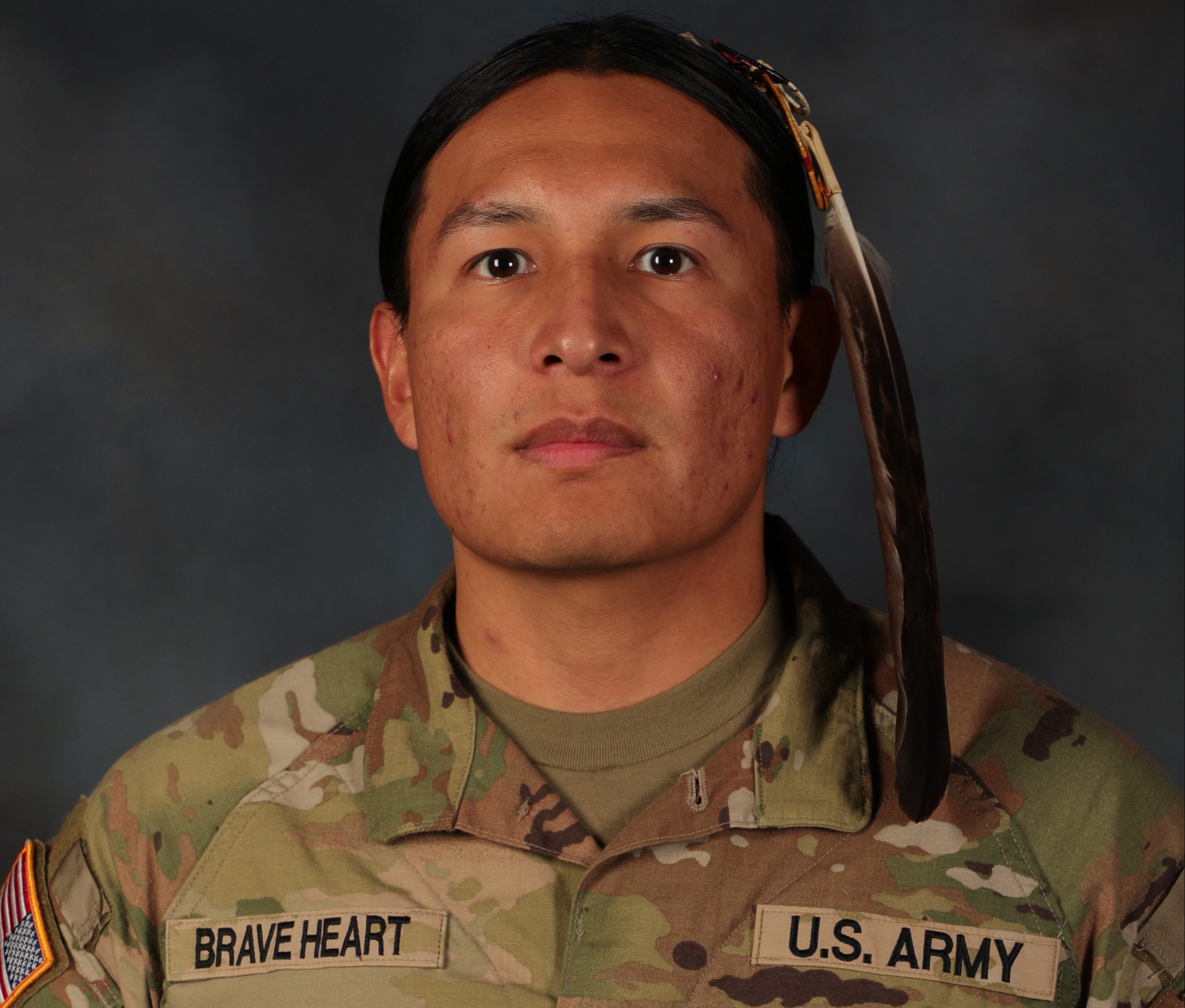 A profile photo of Spec. Moses Brave Heart, in his National Guard uniform with a feather in his hair.