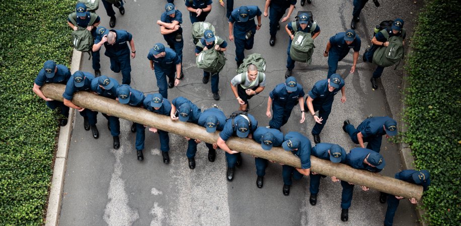 U.S. Coast Guard Cadets carry a log uphill during sea trials at the Academy, New London, Conn., Aug 17, 2024. Sea Trials is a set of daylong exercises that challenges swabs physically and mentally, while also marking the conclusion of the summer training program. (U.S. Coast Guard photo by Petty Officer 3rd Class Matt Thieme.)