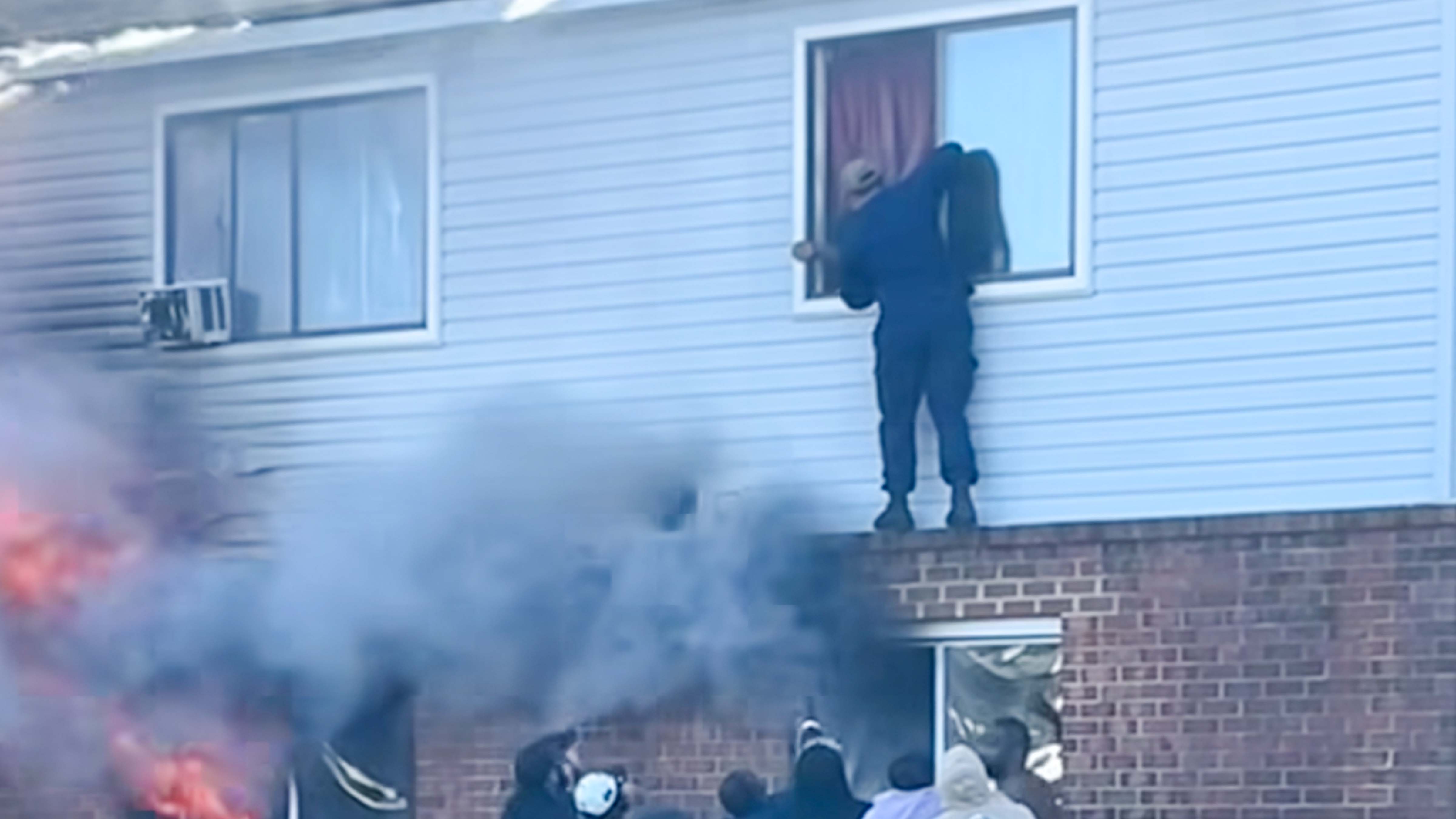 A sailor rescuing an elderly woman from a burning building in Norfolk, Virginia.