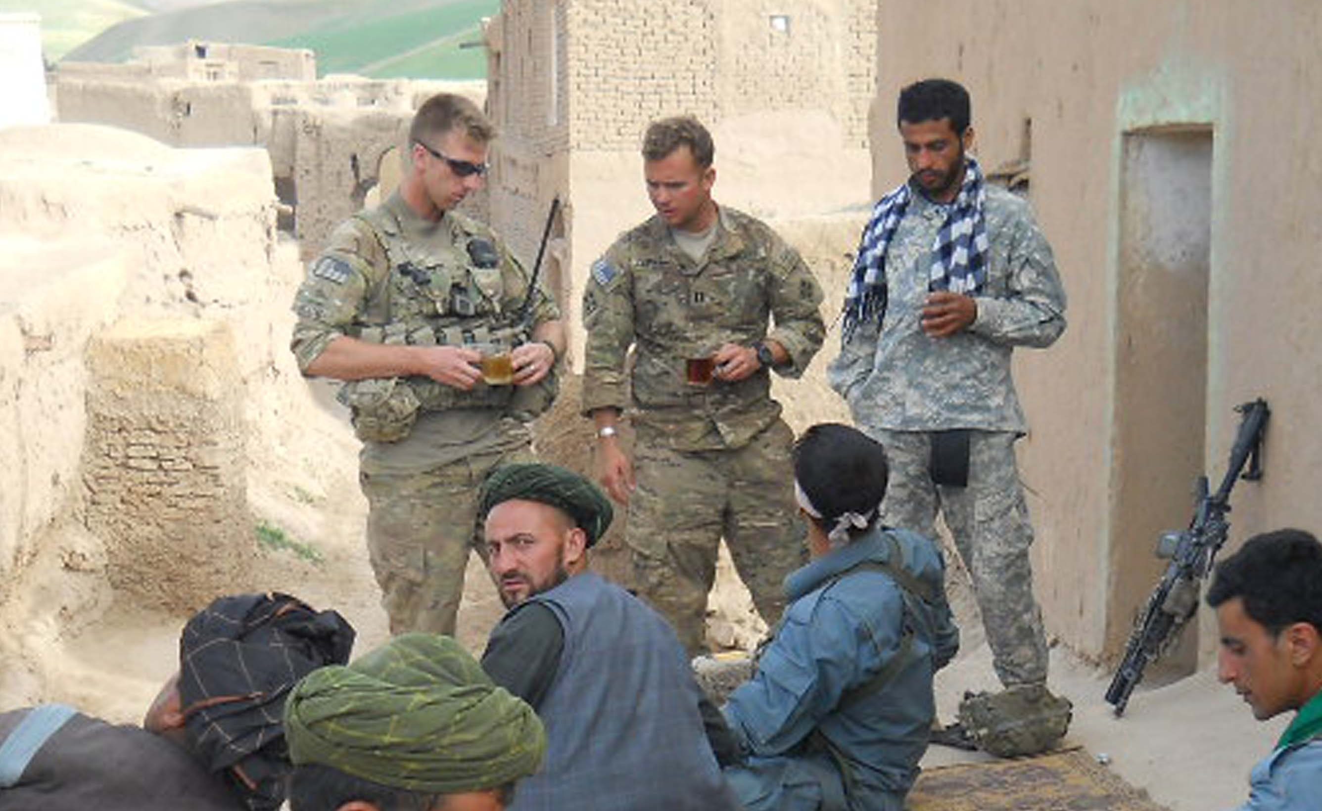 Garrett Cathcart having tea with Taliban fighters, hours after they were shooting at each other.