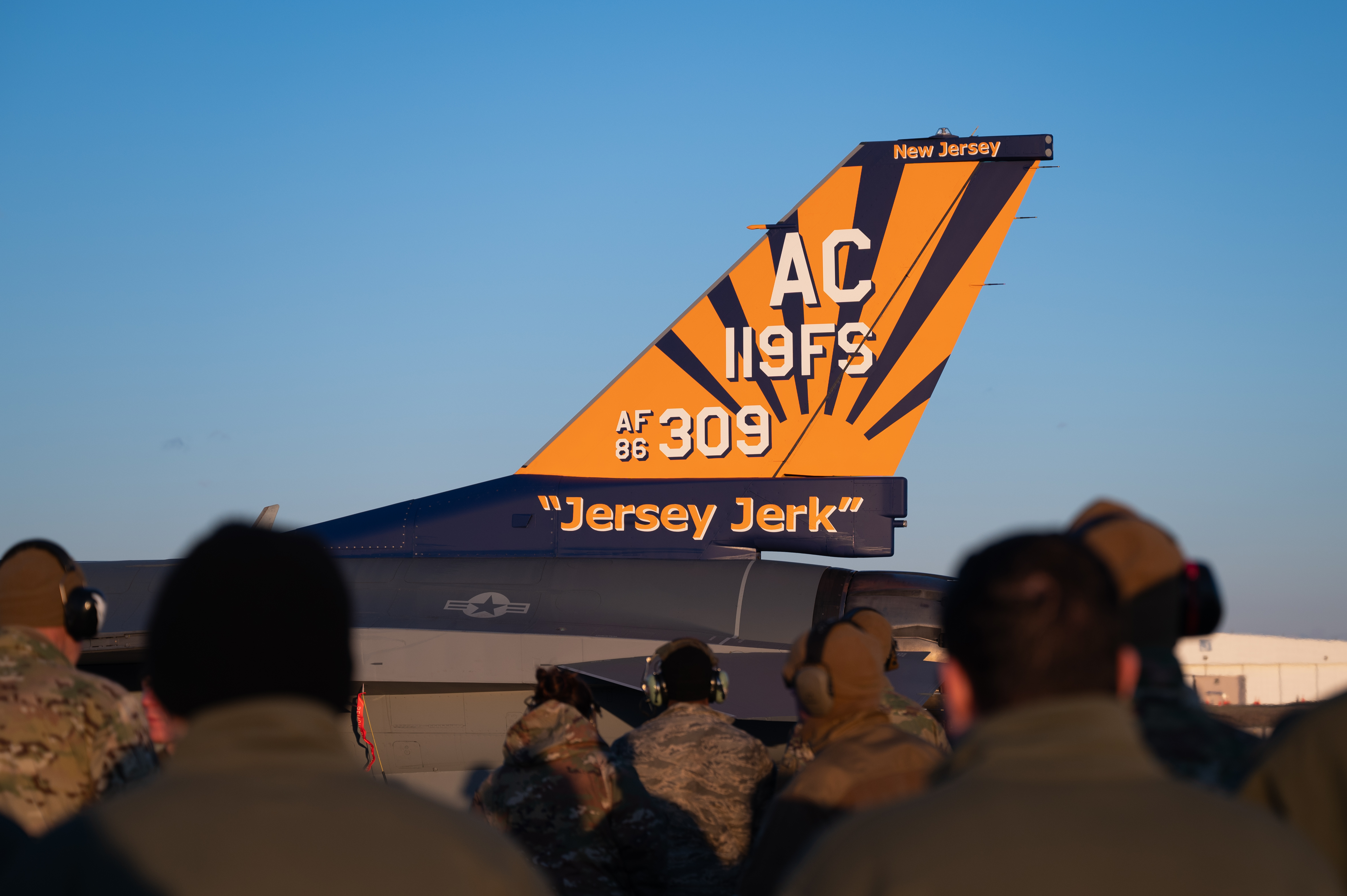 A U.S. Air Force F-16C Fighting Falcon fighter jet assigned to the 119th Fighter Squadron displays the new “Jersey Jerk” flagship tail flash on the flightline at the 177th Fighter Wing, Egg Harbor Township, New Jersey, Dec. 5, 2024. The aircraft is dedicated to U.S. Air Force Maj. Gen. Donald Strait, a retired commander of the New Jersey Air National Guard (NJANG), who flew a P-47 Thunderbolt and a P-51 Mustang of the same name. (U.S. Air National Guard photo by Senior Airman Darion Boyd)