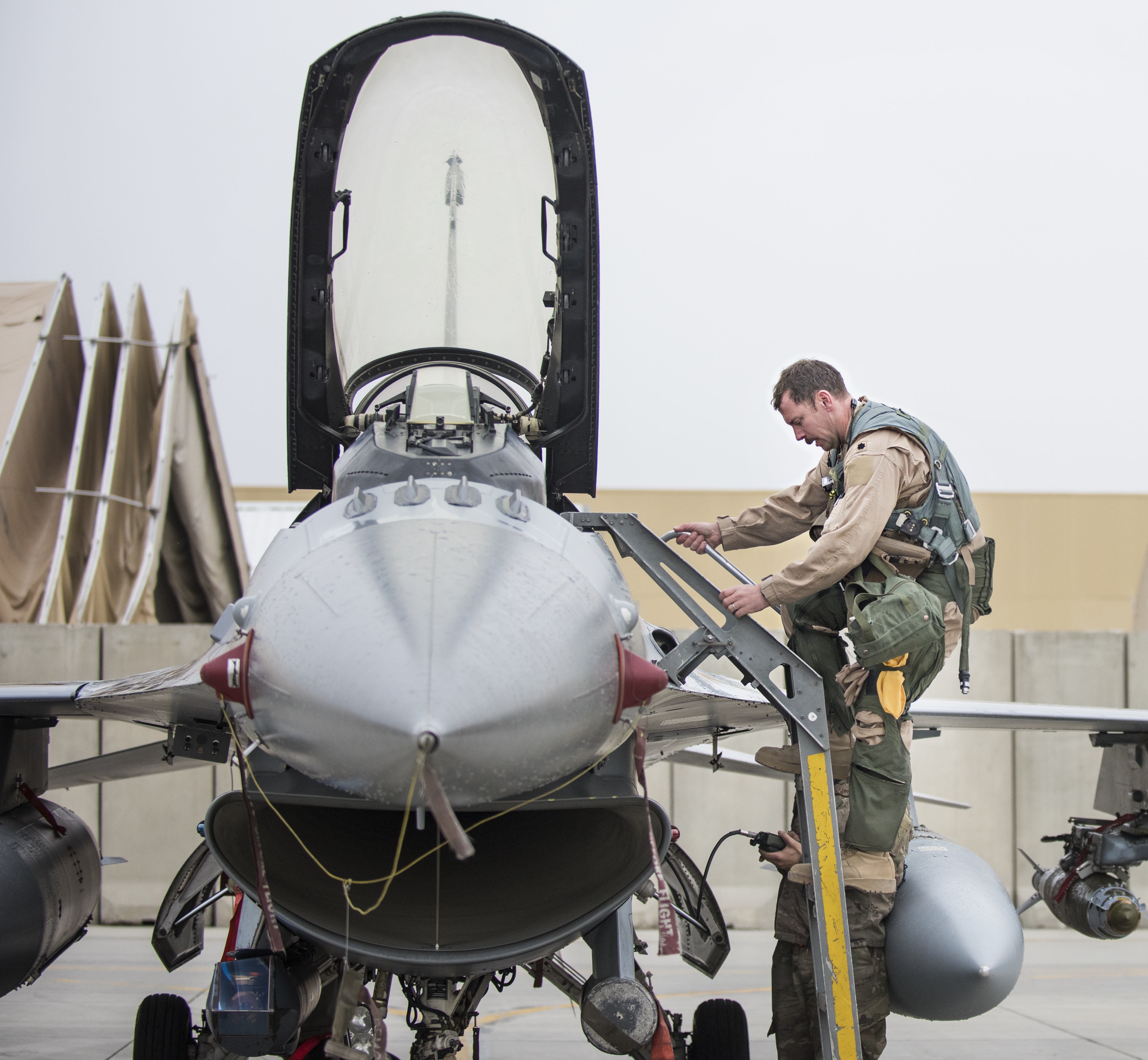 Lt. Col. Craig Andrle, 79th Expeditionary Fighter Squadron commander, climbs down from an F-16 Fighting Falcon as members of the 79th EFS wait to congratulate him on flying his 1,000th combat hour March 20, 2017 at Bagram Airfield, Afghanistan. Andrle reached the milestone while supporting the wing’s counterterrorism mission in Afghanistan. (U.S. Air Force photo by Staff Sgt. Katherine Spessa)