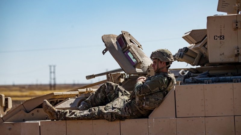 A US soldier rests on a tank as troops patrol oil fields near Syria's northeastern border with Turkey in the Qahtaniyah countryside in the far northeast corner of Hasakeh province on September 3, 2024. The United States has around 900 troops in Syria that are part of an anti-jihadist coalition and also have forces protecting the Conoco gas field and Al-Omar oil fields in east of the country. (Photo by DELIL SOULEIMAN / AFP) (Photo by DELIL SOULEIMAN/AFP via Getty Images)