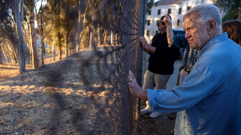 Judge David O. Carter looks at the West Los Angeles Veterans Affairs campus through a chainlink fence.