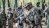 Soldiers in uniform and camouflage consult documents while in the field.